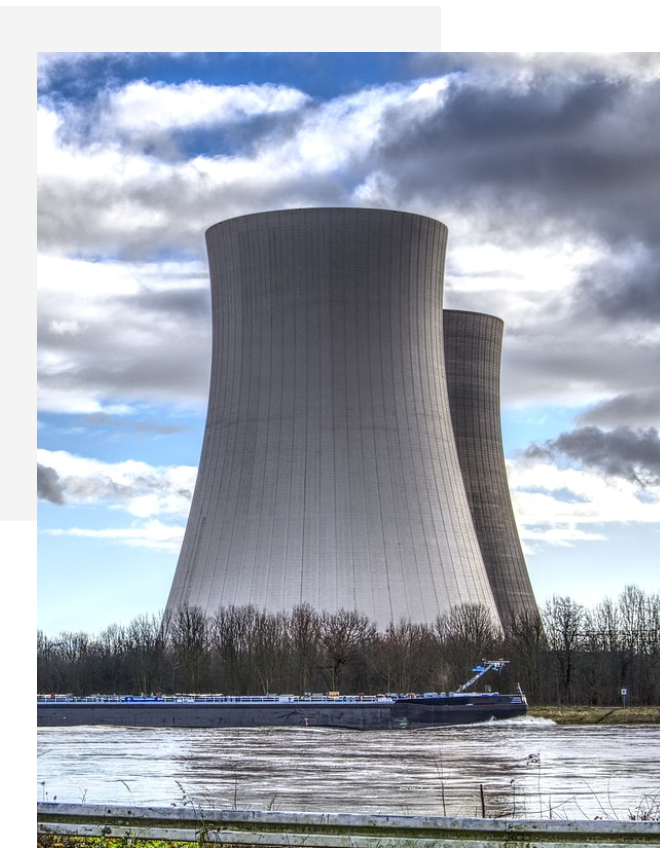 A large white building with two cooling towers.