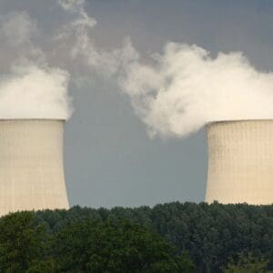 Two towers with smoke coming out of them.